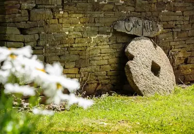 a large rock sitting next to a brick wall at River Cottage@Cwm Mill - Riverside Family Holidays in the Black Mountains in Hereford
