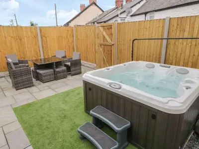 a hot tub in a yard with a table and a fence at The Blue Lion in Cynwyd