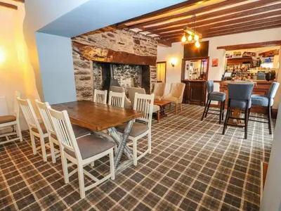 a dining room with a wooden table and chairs at The Blue Lion in Cynwyd