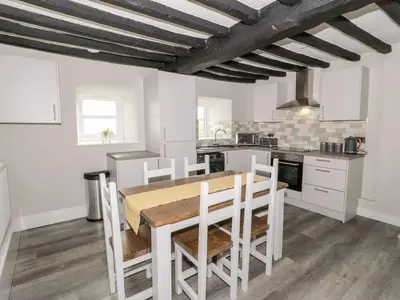 a kitchen with a table and chairs in a room at The Blue Lion in Cynwyd