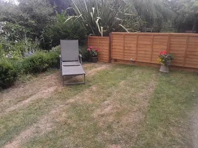 a chair sitting in a yard next to a fence at THE RETREAT in Hereford