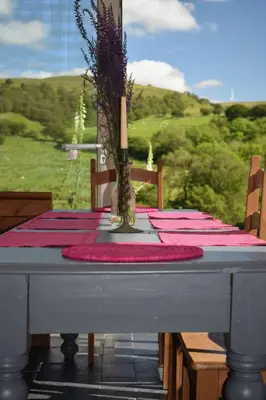 a table with a red table cloth and a candle on it at Healing Pastures Farm in Llanbrynmair