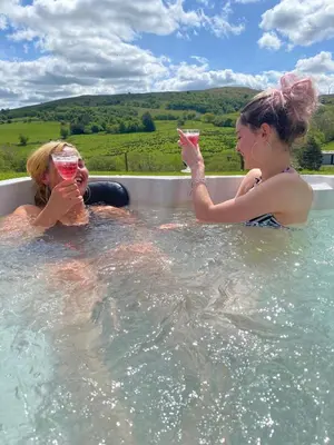 two women drinking wine in a swimming pool at Healing Pastures Farm in Llanbrynmair