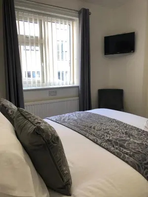 a bedroom with a bed with pillows and a window at The Bell Hotel in Newtown