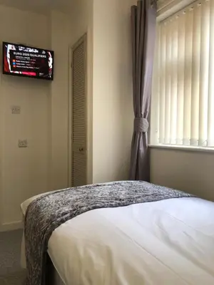 a bedroom with a bed and a window and a television at The Bell Hotel in Newtown