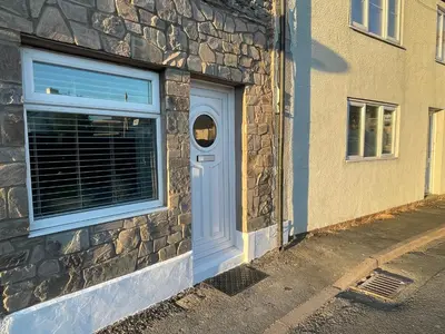 a blue door on the side of a stone building at Westend Holiday Let 1 Brecon in Brecon