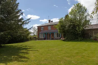 an old brick house with a large yard at Lower Buckton Country House in Leintwardine