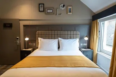 a bedroom with a bed with two pillows and a window at The Feathers Hotel in Ludlow
