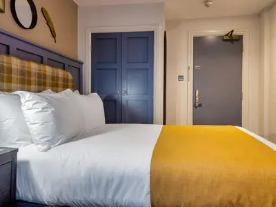 a bedroom with a large white bed with a yellow blanket at The Feathers Hotel in Ludlow