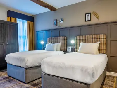 two beds in a room with blue walls at The Feathers Hotel in Ludlow