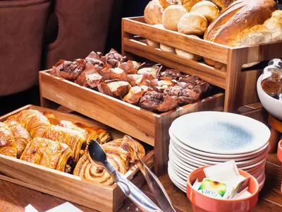 a table with two wooden trays of different types of bread at The Feathers Hotel in Ludlow