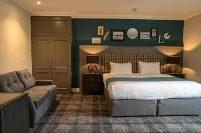 a hotel room with a bed and a couch at The Feathers Hotel in Ludlow