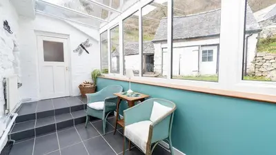a balcony with chairs and a table and windows at Maes Glas in Mallwyd