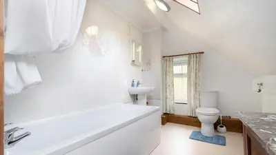 a bathroom with a tub and a toilet and a sink at Maes Glas in Mallwyd