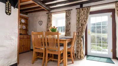 a dining room with a table and chairs and a window at Maes Glas in Mallwyd