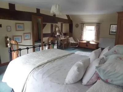 a bedroom with a large bed with white sheets and pillows at Walford Court in Leintwardine