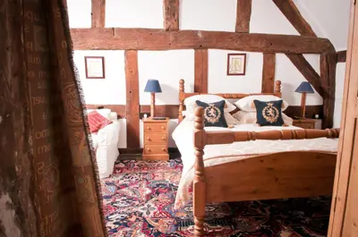 a bedroom with a wooden bed with blue pillows at Walford Court in Leintwardine
