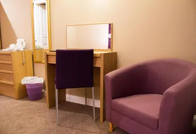 a room with a desk with a chair and a mirror at Gwesty Minffordd Hotel in Tal-y-llyn