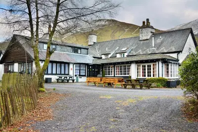 a building with picnic tables in front of it at Gwesty Minffordd Hotel in Tal-y-llyn