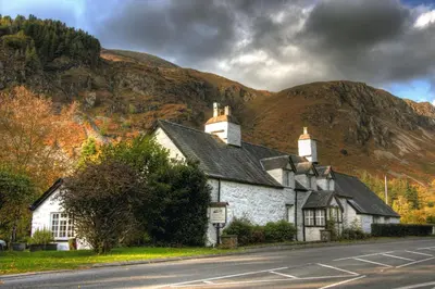a building on the side of a road in front of a mountain at Gwesty Minffordd Hotel in Tal-y-llyn