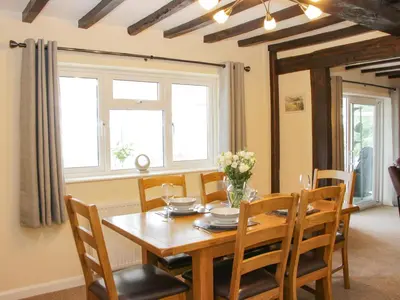 a dining room with a wooden table and chairs at Caesamson in Caersws