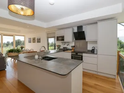 a kitchen with white cabinets and a large island at The Dutch Barn in Leominster
