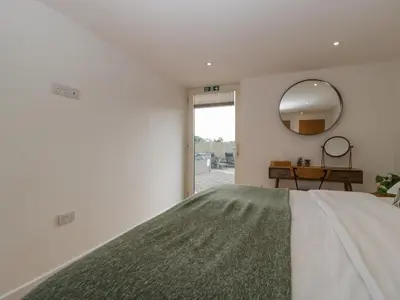 a bedroom with a large bed and a mirror at The Dutch Barn in Leominster