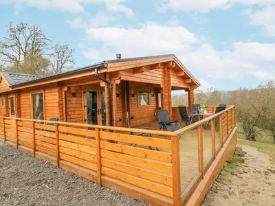 a log cabin with a large deck at Manor Farm Lodges - Red Kite Lodge in Newtown