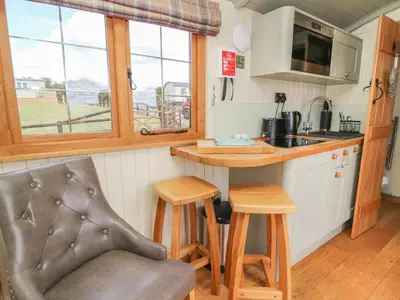 a kitchen with a counter and a table and chairs at Ivy's Way in Rhayader