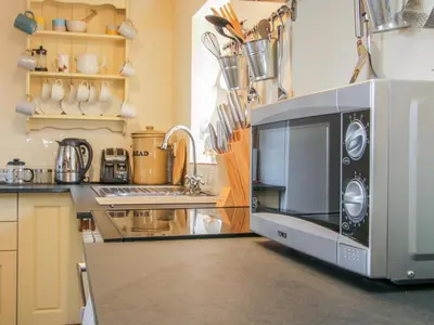 a kitchen with a microwave oven sitting on a counter at High Grove in Ludlow