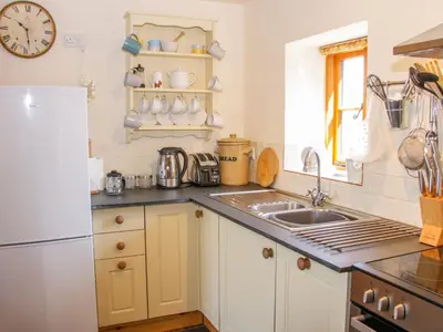 a kitchen with a sink and a refrigerator at High Grove in Ludlow