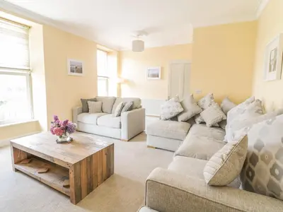 a living room with two couches and a coffee table at Angorfa in Llanbedr