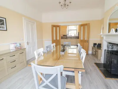 a kitchen and dining room with a table and chairs at Angorfa in Llanbedr