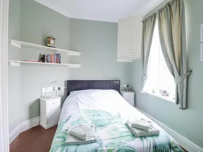 a bed in a room with a window and a bed sidx sidx sidx at Minydon in Fairbourne