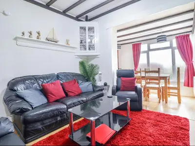 a living room with a leather couch and a table at Minydon in Fairbourne