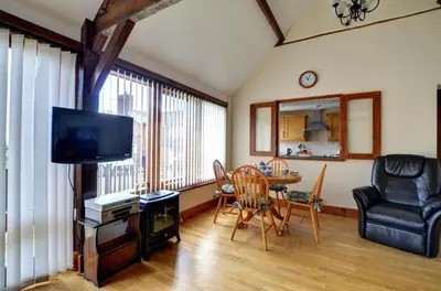 a living room with a television and a table and chairs at 2 Bed in Welshpool oc-wab256 in Berriew