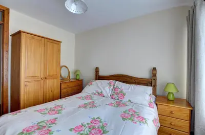 a bedroom with a bed with pink flowers on it at 2 Bed in Welshpool oc-wab256 in Berriew