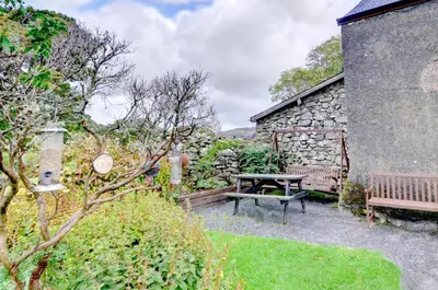 a picnic table and a bench in a garden at 3 Bed in Dolgellau oc-wah464 in Llanfachreth