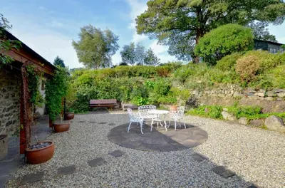 a patio with a table and chairs and a bench at 2 Bed in Tywyn oc-wah595 in Llanegryn