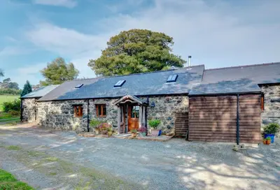 a stone house with solar panels on the roof at 2 Bed in Tywyn oc-wah595 in Llanegryn