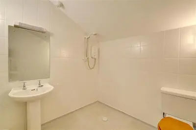 a white bathroom with a sink and a mirror at 2 Bed in Tywyn oc-wah595 in Llanegryn