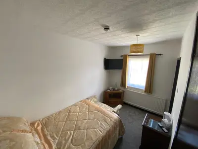 a small bedroom with a bed and a window at The Griffin Llyswen in Brecon