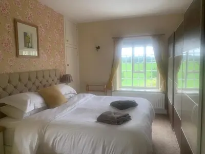 a bedroom with a bed with two towels on it at Mid-Wales Farmhouse, swimming pool, tranquil countryside views, sleeps 14 in Meifod