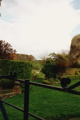 a fence with a view of a green field at Courtyard Cottage in Oswestry