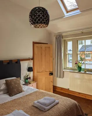 a bedroom with a bed and a window at Courtyard Cottage in Oswestry