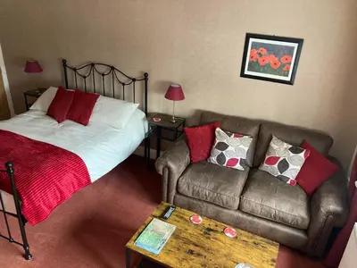 a bedroom with a bed and a couch and a table at Birchwood House in Church Stretton
