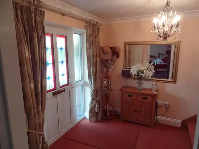 a room with a door and a mirror and a table at Birchwood House in Church Stretton