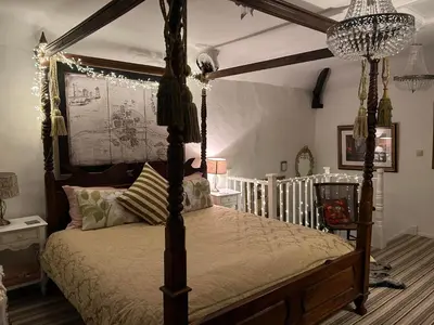 a bedroom with a canopy bed and a chandelier at 8 Opera Suites, Llangollen in Llangollen