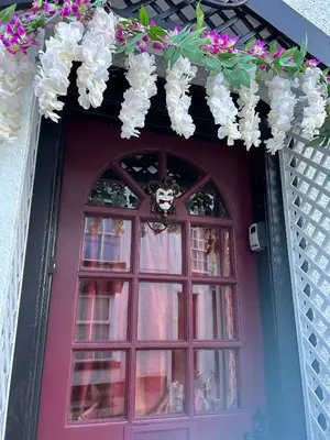 a purple door with a window and flowers on it at 8 Opera Suites, Llangollen in Llangollen