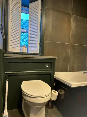 a bathroom with a toilet and a sink and a window at 8 Opera Suites, Llangollen in Llangollen